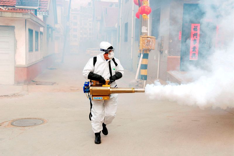 &copy; Reuters. FOTO DE ARCHIVO: Un trabajador desinfecta el pueblo de Dongxinzhuang en Qingdao, provincia de Shandong, China 29 de enero de 2020