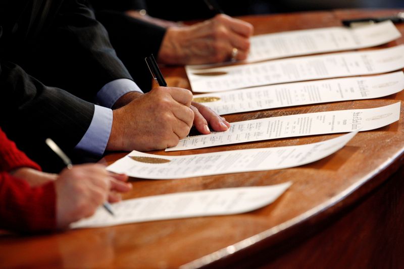 © Reuters. FILE PHOTO: North Carolina Electoral College representatives sign the Certificates of Vote in the State Capitol building in Raleigh, North Carolina