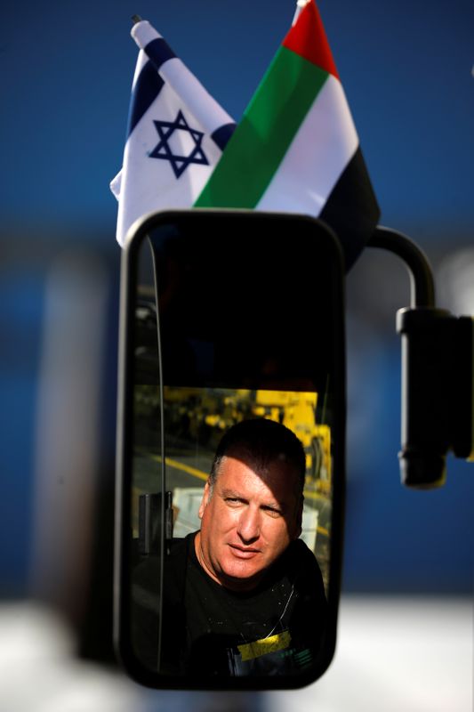 © Reuters. Worker sits inside a truck bearing Israeli and Emirati flags at Haifa's port