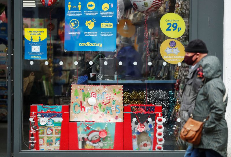 &copy; Reuters. Personas con mascarillas pasan por delante de un escaparate con decoraciones navideñas en Newcastle Upon Tyne, Reino Unido, el 12 de octubre de 2020