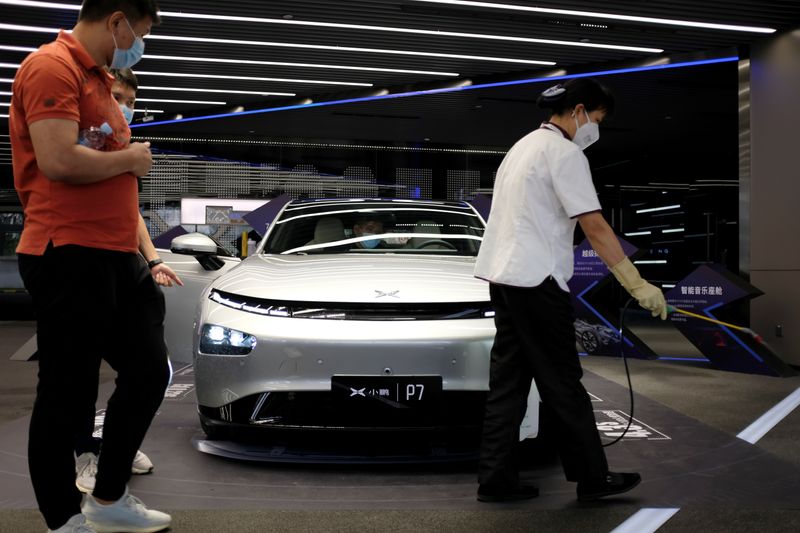 &copy; Reuters. Staff sprays disinfectant near Xpeng P7 sedan displayed at XPeng Motors headquarters in Guangzhou
