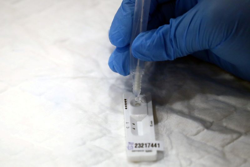&copy; Reuters. FILE PHOTO: A health worker performs a coronavirus disease (COVID-19) antigen test in Madrid