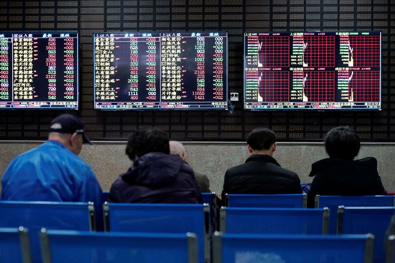 &copy; Reuters. Investors look at screens showing stock information at a brokerage house in Shanghai