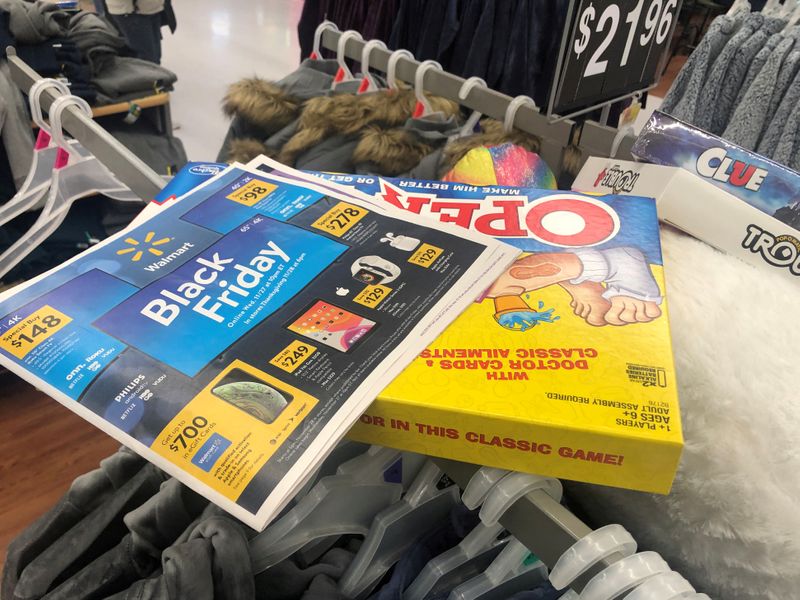 © Reuters. FILE PHOTO: Black Friday ads lay on top of clothes during a sales event on Thanksgiving day at Walmart in Westbury, New York