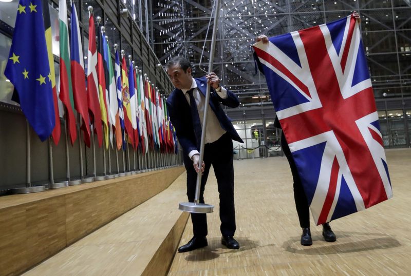 &copy; Reuters. FILE PHOTO: Officials remove the British flag at EU Council in Brussels