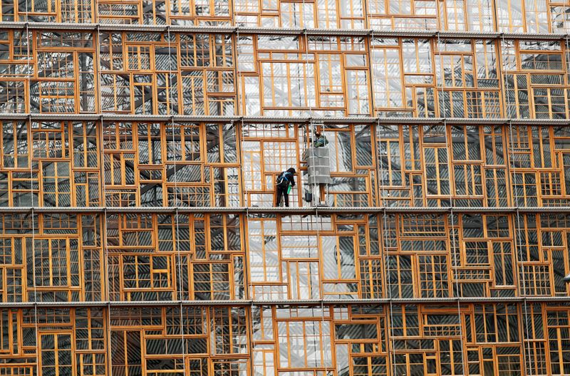 © Reuters. FILE PHOTO: Window cleaners work on the facade of the European Union Council building in Brussels