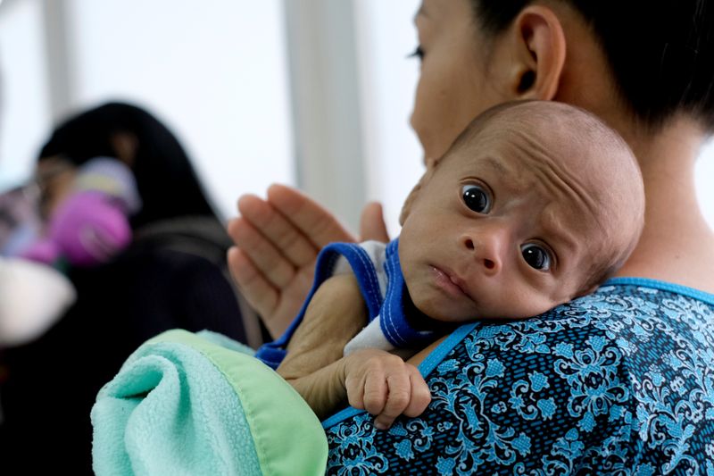 &copy; Reuters. Mãe aguarda com seu filho de 2 meses, diagnosticado com desnutrição, por exame em clínica venezuelana