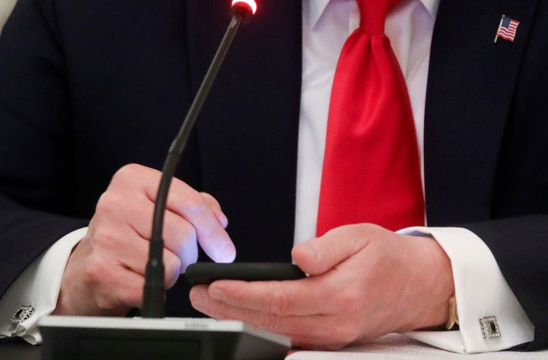 &copy; Reuters. FOTO DE ARCHIVO. El presidente de Estados Unidos, Donald Trump, toca la pantalla de un teléfono móvil durante una mesa redonda en la Casa Blanca en Washington