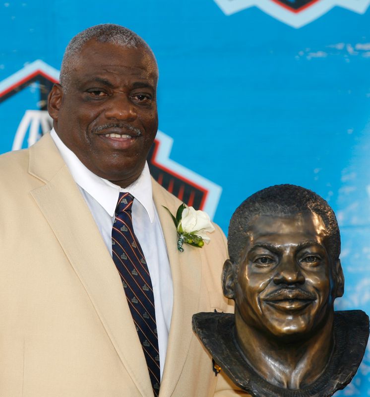 © Reuters. FILE PHOTO: Former NFL player Fred Dean poses with his bust after being inducted into the Pro Football Hall of Fame in Canton