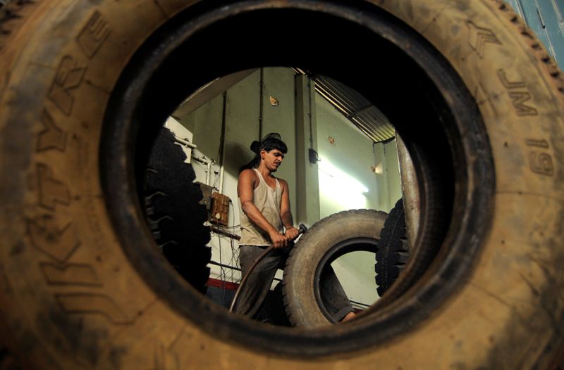 &copy; Reuters. FILE PHOTO: A worker retreads a used rubber tyre at a workshop in Agartala