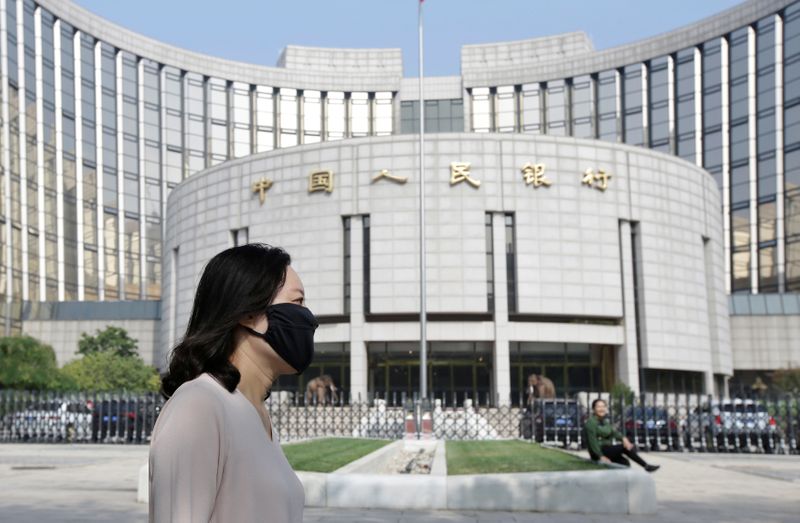 &copy; Reuters. A woman walks past the headquarters of the PBOC, the central bank, in Beijing