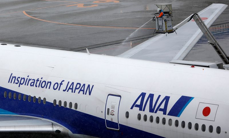 &copy; Reuters. A man works near an All Nippon Airways&apos; (ANA) air plane parked at Haneda airport in Tokyo