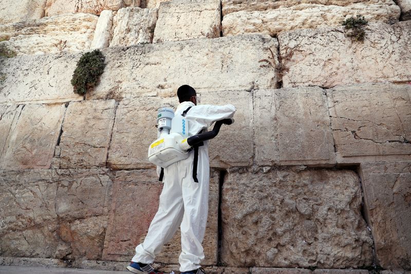 &copy; Reuters. A labourer disinfects as he clears notes from Western Wall in Jerusalem&apos;s Old City