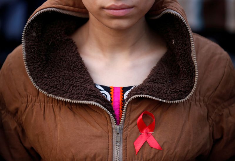 &copy; Reuters. FOTO DE ARCHIVO. Imagen referencial de una mujer con un lazo rojo participando en una campaña de sensibilización sobre el VIH/SIDA, antes del Día Mundial del Sida, en Katmandú, Nepal