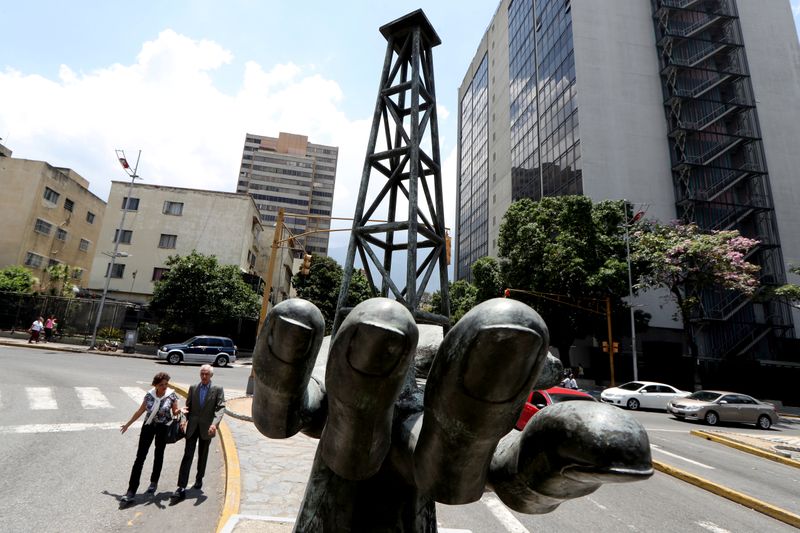 &copy; Reuters. La gente pasa junto a una escultura fuera de un edificio de la petrolera estatal de Venezuela PDVSA en Caracas