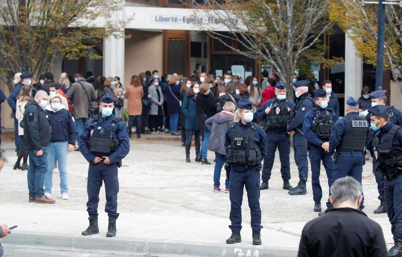 © Reuters. People gather in front of the Bois d'Aulne college after the attack in the Paris suburb of Conflans St Honorine