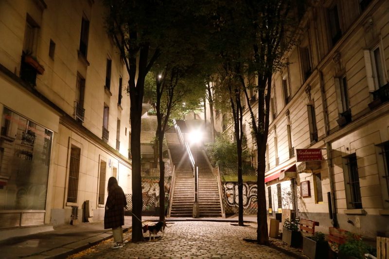 &copy; Reuters. A woman walks her dog in Montmartre during the late-night curfew due to restrictions against the spread of the coronavirus disease (COVID-19) in Paris
