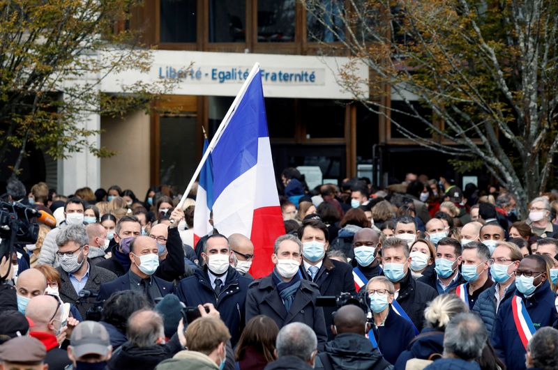 &copy; Reuters. FILE PHOTO: People gather in front of the Bois d&apos;Aulne college after the attack in the Paris suburb of Conflans St Honorine