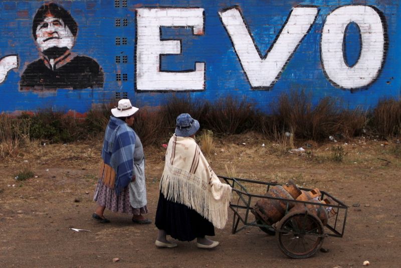 &copy; Reuters. Women walk past a wall with a graffiti depicting former Bolivian President Evo Morales, before general elections in La Paz