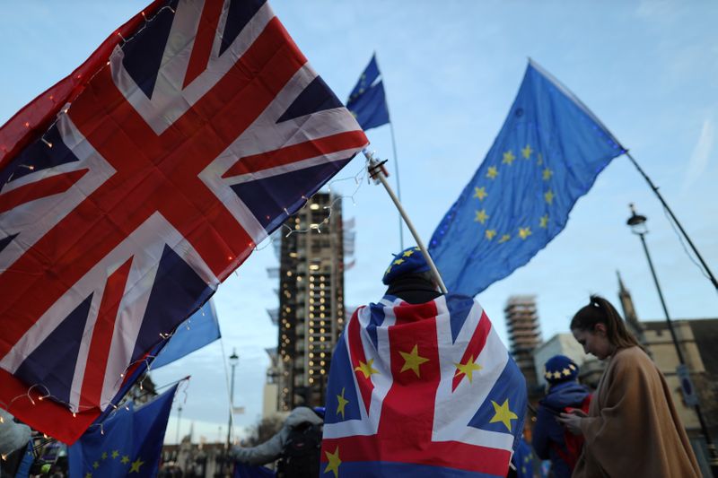 &copy; Reuters. A man is seen holding EU and Britain flag outside the Houses of Parliament in London