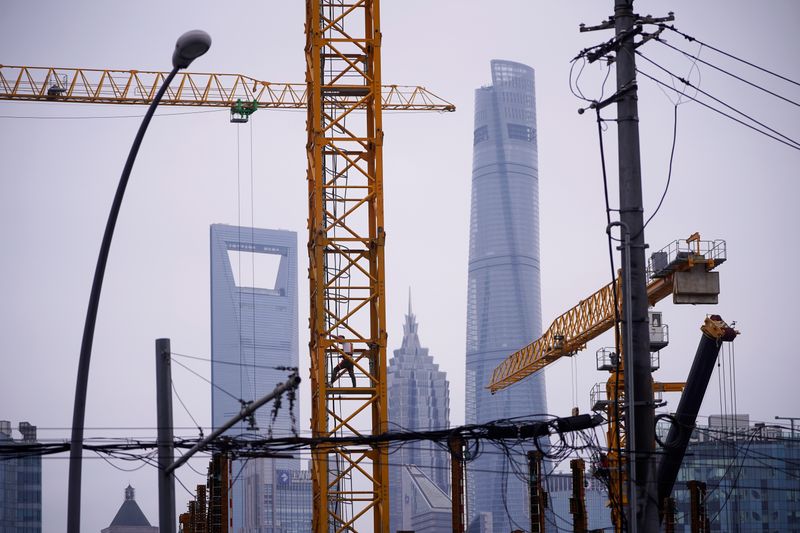 &copy; Reuters. A worker is seen on a crane at a construction site in front of Lujiazui financial district, in Shanghai