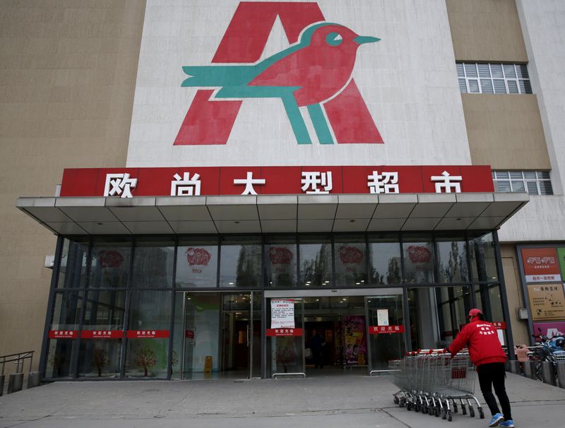 &copy; Reuters. FILE PHOTO: An employee carries shopping carts into Sun Art Retail Group&apos;s Auchan hypermarket store in Beijing,