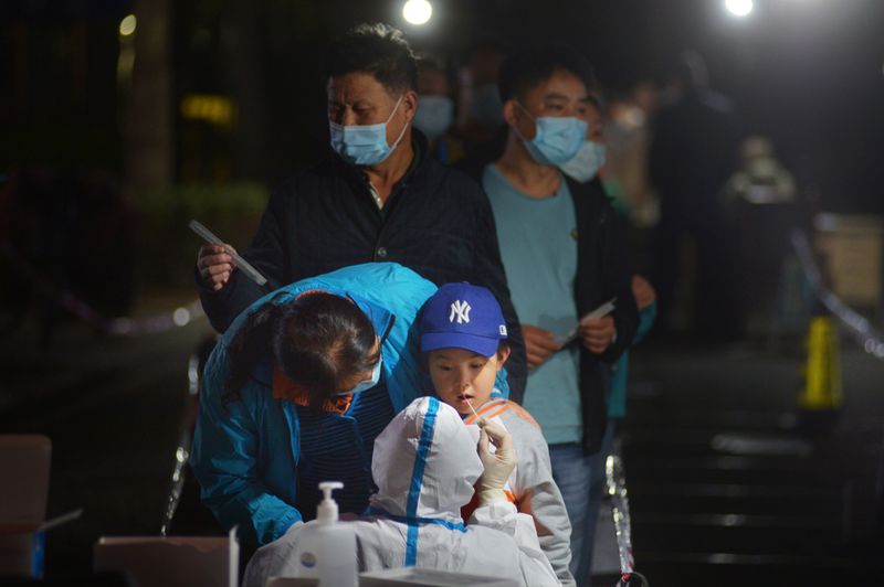 &copy; Reuters. FOTO DE ARCHIVO: Un trabajador sanitario realiza una prueba en un niño en Qingdao, provincia de Shandong, China 13 de octubre de 2020