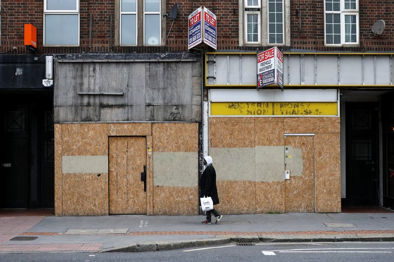 &copy; Reuters. Pedestrian walks past bordered up retail stores in Croydon, south London