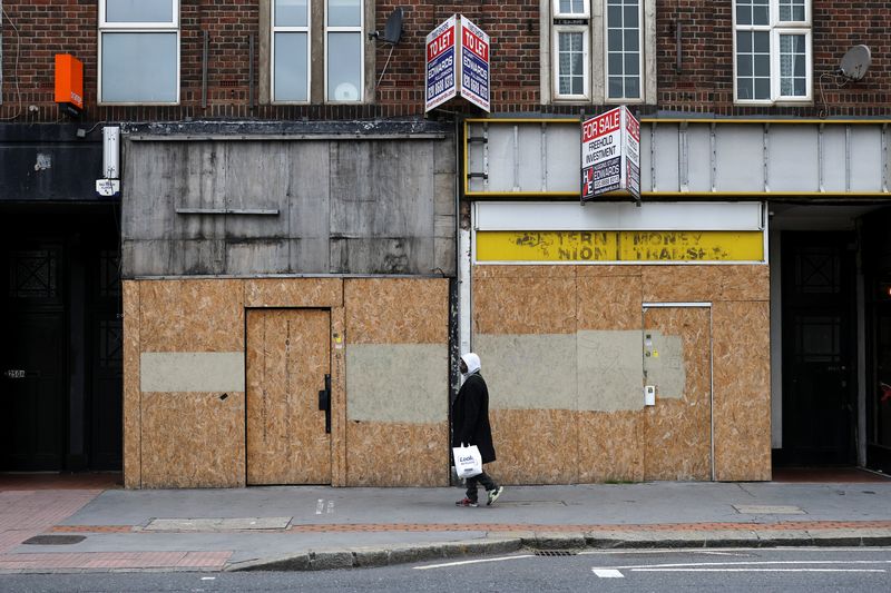 © Reuters. Pedestrian walks past bordered up retail stores in Croydon, south London