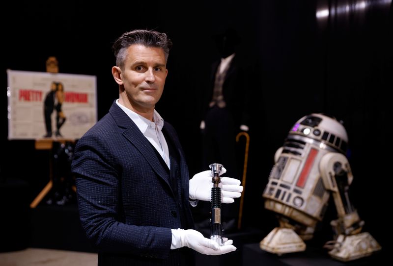&copy; Reuters. Stephen Lane, CEO of Prop Store, poses for a photograph with Obi-Wan Kenobi&apos;s Hero Lightsaber from Star Wars: Revenge of the Sith, at a preview of a movie and TV memorabilia auction in Rickmansworth
