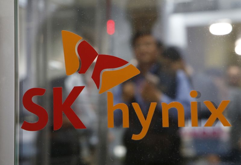 © Reuters. Employee walk past the logo of SK Hynix at its headquarters in Seongnam