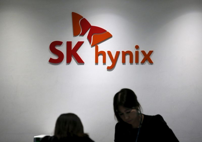 © Reuters. FILE PHOTO: Employees talk in front of the logo of SK Hynix at its headquarters in Seongnam