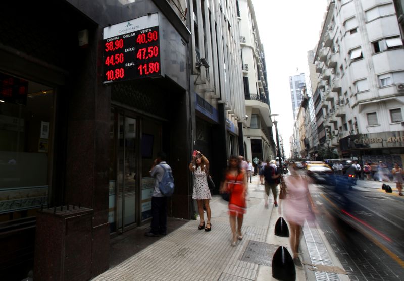 &copy; Reuters. A woman takes a picture of an electronic board showing currency exchange rates in Buenos Aires&apos; financial district