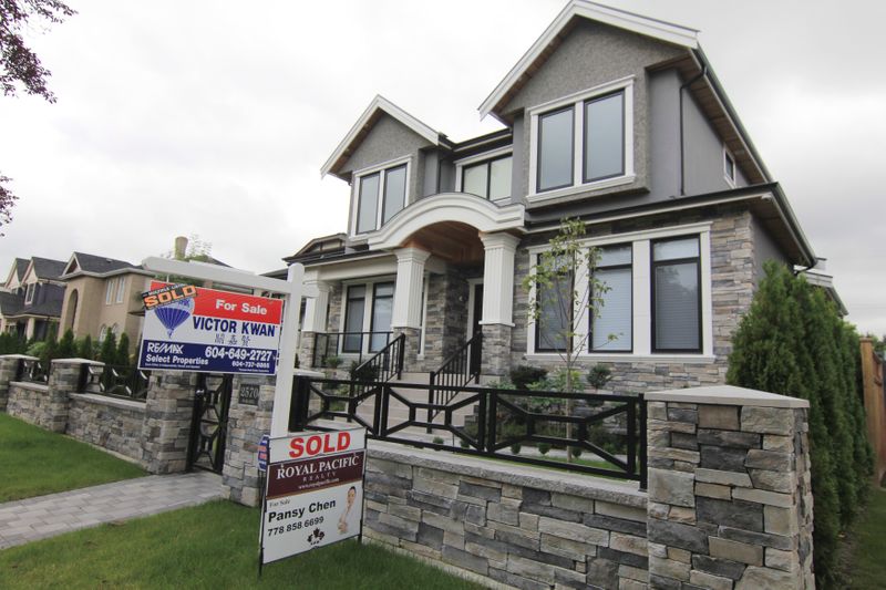 &copy; Reuters. Realtors&apos; signs are hung outside a newly sold property in a Vancouver neighborhood