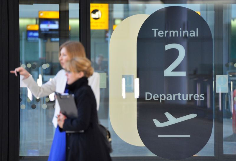 © Reuters. FILE PHOTO: Visitors are seen in a doorway at the departure area of the new 'Terminal 2: The Queen's Terminal' during a media event in Heathrow Airport, west London