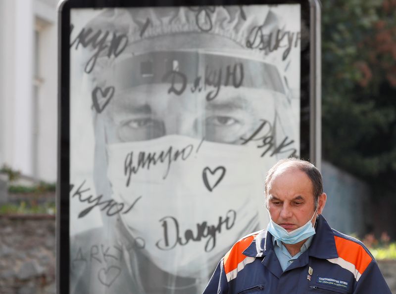 &copy; Reuters. Man walks past a poster with thanks to the doctors amid the COVID-19 outbreak in central Kiev