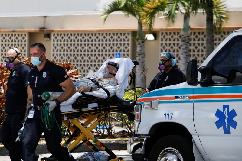 &copy; Reuters. Emergency Medical Technicians (EMT) leave with a patient at Hialeah Hospital where the coronavirus disease (COVID-19) patients are treated