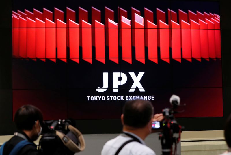 &copy; Reuters. Due reporter davanti al logo della Borsa di Tokyo