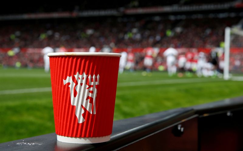 © Reuters. FILE PHOTO: A Manchester United branded coffee cup sits on a trackside LED advertising board during the Manchester United v Swansea City Premier League football match