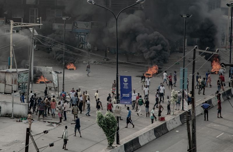 &copy; Reuters. People are seen near burning tires on the street, in Lagos