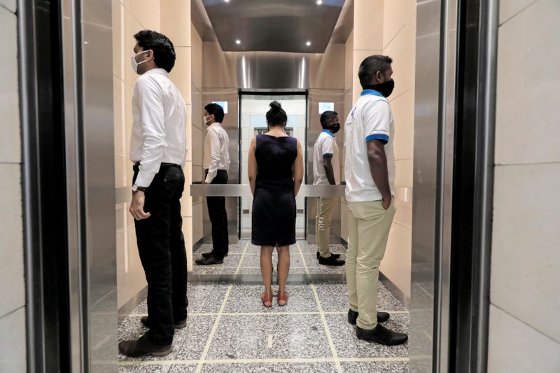 &copy; Reuters. FILE PHOTO: People practice social distancing inside an elevator at World Trade Center in Colombo, Sri Lanka