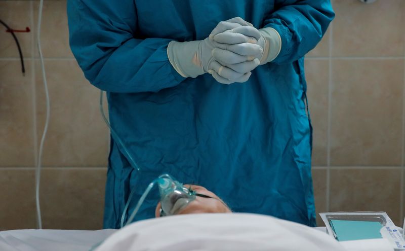 &copy; Reuters. Un operatore sanitario osserva un paziente in terapia intensiva in un ospedale a Mosca, in Russia