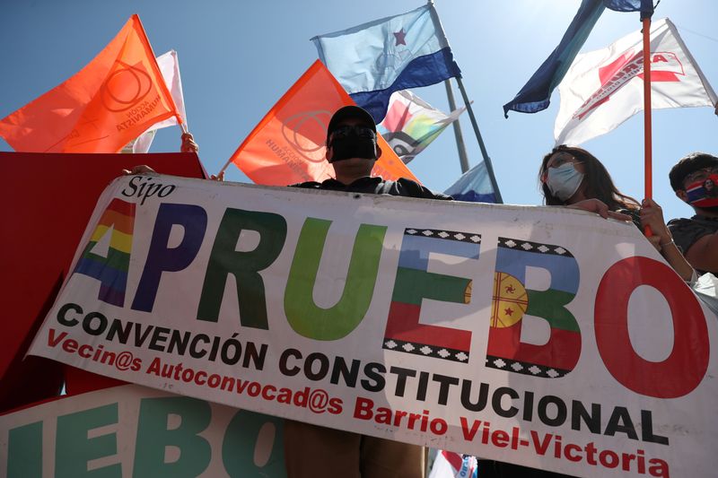 &copy; Reuters. FILE PHOTO: An activist holds a sign reading &quot;I approve, constitutional convention&quot; ahead of the upcoming referendum on a new Chilean constitution in Santiago