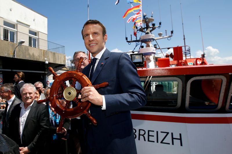 © Reuters. FILE PHOTO: French President Emmanuel Macron receives a gift on a trawler as he visits the harbour of Lorient
