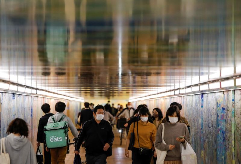 &copy; Reuters. Passersby wearing protective face masks are seen at an underpass, amid the coronavirus disease (COVID-19) outbreak, in Tokyo