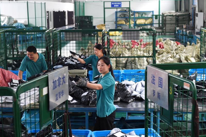 &copy; Reuters. FOTO DE ARCHIVO: Varios trabajadores distribuyen envíos postales en un complejo industrial de comercio electrónico en Hefei, provincia de Anhui