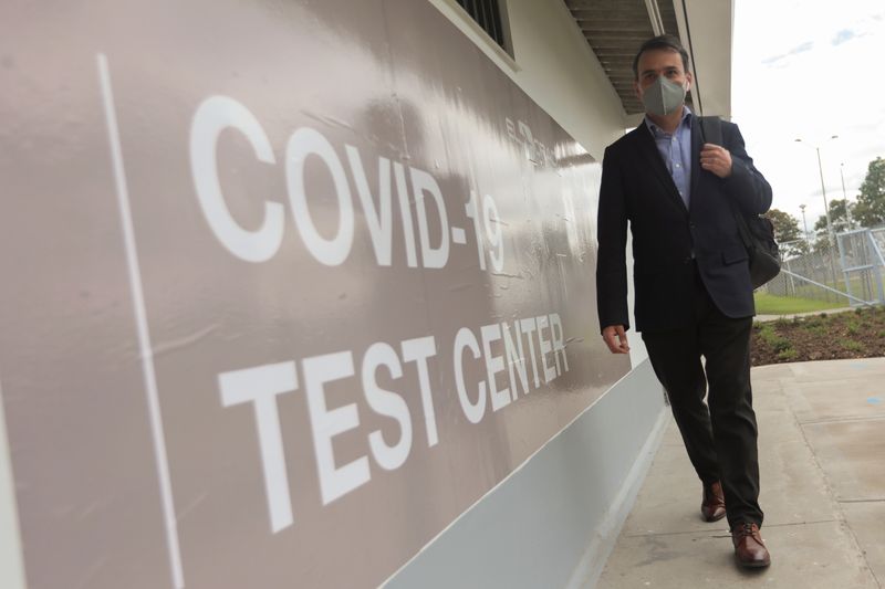 &copy; Reuters. A man wearing a face mask walks near the entrance of the Synlab laboratory where tests for the coronavirus disease (COVID-19) are processed at El Dorado airport in Bogota