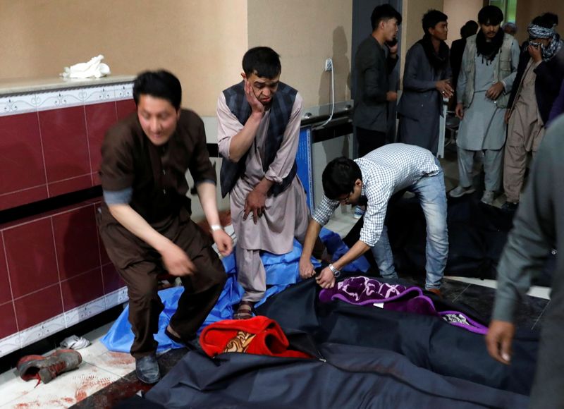 &copy; Reuters. Hombres afganos buscan a sus familiares en un hospital luego de un ataque suicida en Kabul