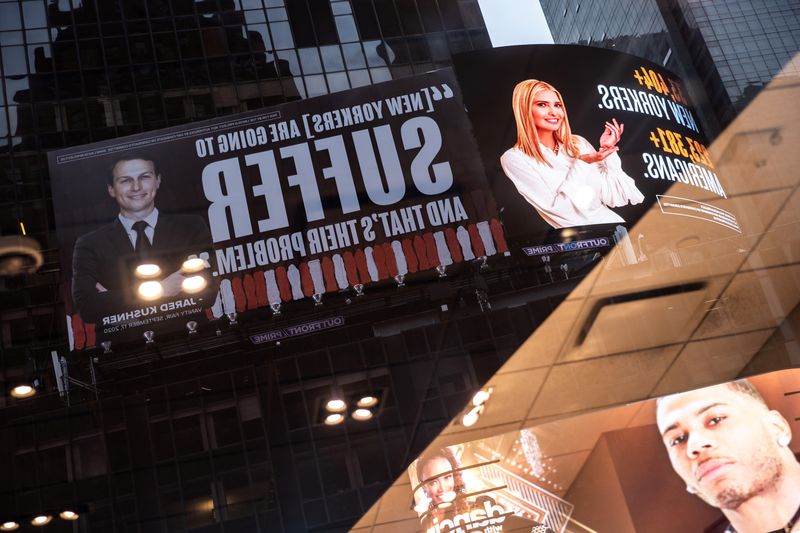 © Reuters. Images of Ivanka Trump and Jared Kushner are seen alongside messages about coronavirus disease in New York