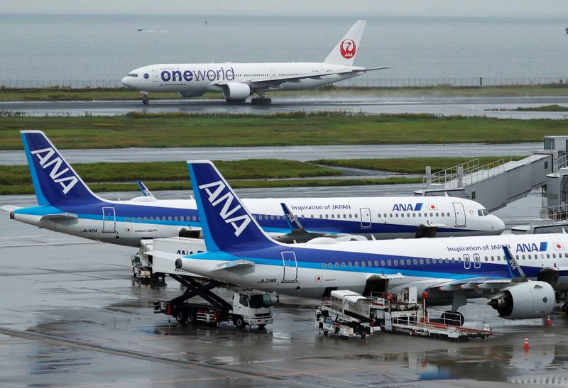 &copy; Reuters. A Japan Airlines (JAL) aircraft takes off near All Nippon Airways (ANA) aircrafts, amid the coronavirus disease (COVID-19) outbreak at Haneda Airport in Tokyo